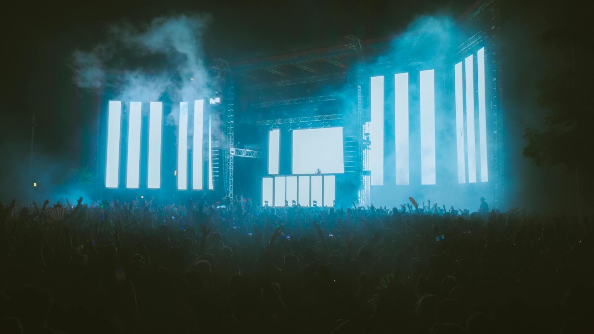 Rave crowd with LED lights neon colors and energetic dancing